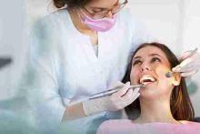 Dentist in Dartford providing urgent dental support and check-up to a smiling female patient.