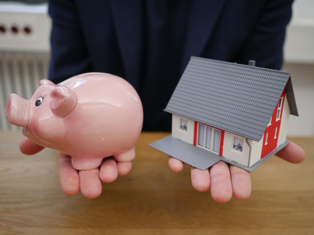 model of a house in a persons hand indicating a fix and flip of a house through fix and flip loan.