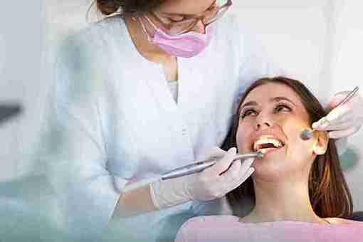 Dentist in Dartford providing urgent dental support and check-up to a smiling female patient.